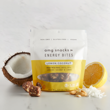 Load image into Gallery viewer, Lemon Coconut Energy Bites on a white background with half of a coconut and lemon.