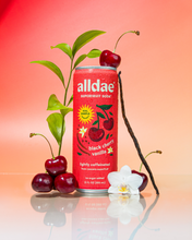 Load image into Gallery viewer, alldae superfruit soda Black Cherry Vanilla sits next to real black cherries and real vanilla bean.