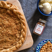 Load image into Gallery viewer, Apple pie with a braided crust on a wooden board, next to a jar of Royal Cinnamon from Burlap & Barrel