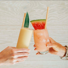 Load image into Gallery viewer, Hand cheersing citrus and watermelon cocktails with reed stem straws
