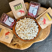 Load image into Gallery viewer, A wood bowl with6 oz bags of Omnivore SALT, LIMONE, PORCINI Salt blends and bags of Ranho Gordo Crimson popping corn with a bowl of pop corn in the center.