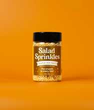Load image into Gallery viewer, A bottle of Maple Sea Salt SaladSprinkles on an orange background