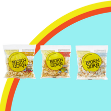 Load image into Gallery viewer, Bjorn Qorn 1 oz bags mix classic spicy salty on rainbow and blue background.