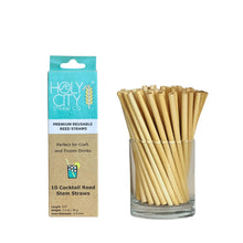 Load image into Gallery viewer, A turquoise-and-brown branded box labeled ‘HolyCity Straw Co. Premium Reusable Reed Straws’ next to a clear glass container filled with multiple short, natural reed straws. The packaging specifies ‘Perfect for Craft and Frozen Drinks’ and ‘10 Cocktail Reed Stem Straws.
