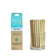 Load image into Gallery viewer, Image of a package and a glass jar containing Holy City Straw Co.'s 5.5-inch reusable cocktail reed straws. The package is light blue and brown, displaying the brand's logo and stating 'Premium Reusable Reed Straws,' ideal for craft and frozen drinks. The jar next to the package is filled with the natural reed straws, showcasing their eco-friendly design.