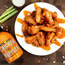 Load image into Gallery viewer, Chicken and waffles served alongside a plate of buffalo wings made with Chicken &amp; Waffles buffalo wing sauce.
