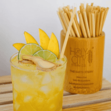 Load image into Gallery viewer, Holy City Straw Company Branded small Bamboo Straw Holder next to citrus drink
