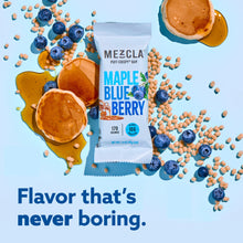 Load image into Gallery viewer, Mezcla Maple Blueberry protein bar package surrounded by blueberries, mini pancakes, maple syrup, and cereal pieces on blue background
