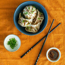 Load image into Gallery viewer, Betty Liu&#39;s Chile Crisp Dust as an oil drizzled on dumplings and bao buns.

