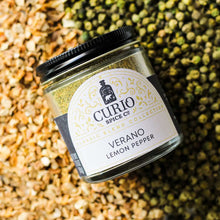 Load image into Gallery viewer, Verano Lemon Pepper jar sitting on a bed of spices used in the blend.
