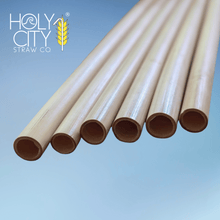 Load image into Gallery viewer, Jumbo reed stem drinking straws by Holy City Straw Co. displayed against a blue backdrop, highlighting their natural hollow texture and sustainable composition
