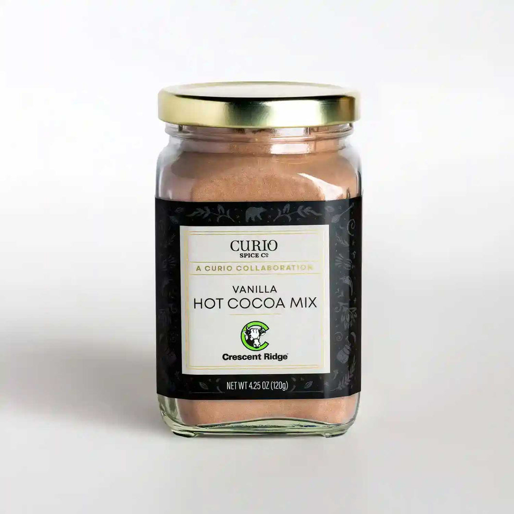 A glass jar of Vanilla Hot Cocoa Mix, a collaboration drink blend with Crescent Ridge and Curio Spice.