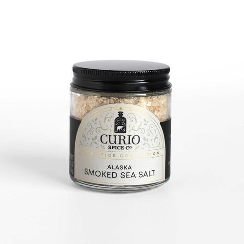 Curio Spice Co. fair-trade single origin sustainable Alaska Alderwood Smoked Sea Salt in a glass jar.